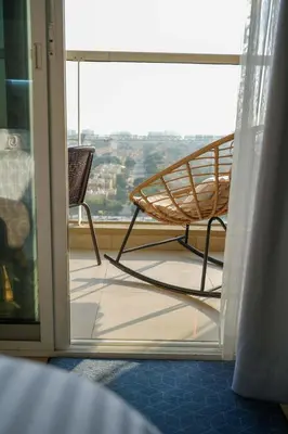 a room with a chair in front of a window at Your comfy stylish studio in Dubai 2guest and baby in Dubai