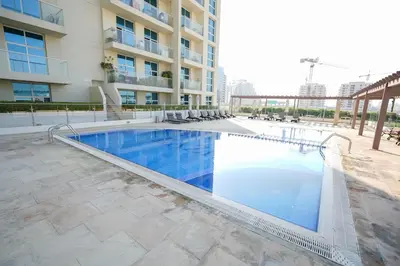 a swimming pool in front of a building at Your comfy stylish studio in Dubai 2guest and baby in Dubai