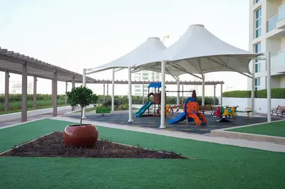 a playground with a tent and a tree in a yard at Your comfy stylish studio in Dubai 2guest and baby in Dubai