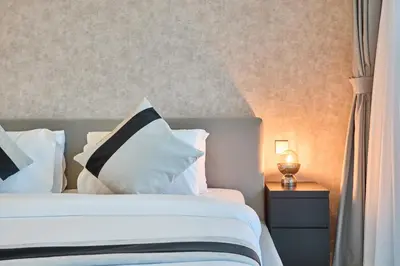 a bedroom with a bed with white and black pillows at Luxury 2BR Apartment in Grand Bleu Tower at EMAAR Beachfront - High Floor with Marina and City View, Private Beach Access by Stayfinity in Dubai