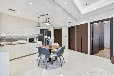 a kitchen and dining room with a table and chairs at Stylish New Apt, Minutes from Downtown Dubai in Dubai