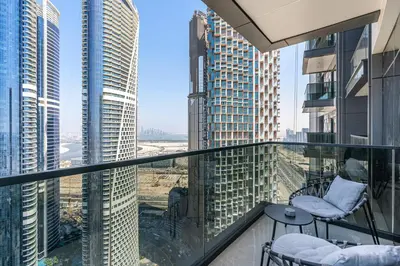 a balcony with chairs and a view of skyscrapers at Stylish New Apt, Minutes from Downtown Dubai in Dubai