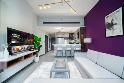 a living room with a white couch and a purple wall at SettlerHomes - Elegant JLT Lakefront Near Metro in Dubai