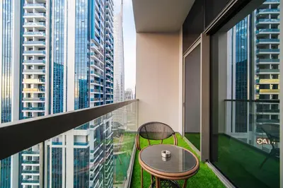 a balcony with a table and chairs in a building at SettlerHomes - Elegant JLT Lakefront Near Metro in Dubai