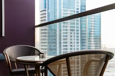 a table and chairs in front of a window at SettlerHomes - Elegant JLT Lakefront Near Metro in Dubai