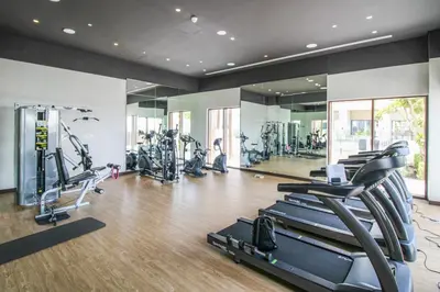 a gym with treadmills and elliptical machines at Luxury 2-Bed Retreat with Stunning Creek Views in Dubai