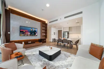 a living room with a couch and a tv at Luxury 2-Bed Retreat with Stunning Creek Views in Dubai