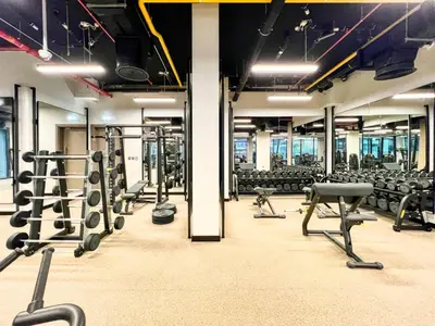a gym with rows of squat racks and chairs at Luxury Studio in Peninsula Five, Business Bay in Dubai