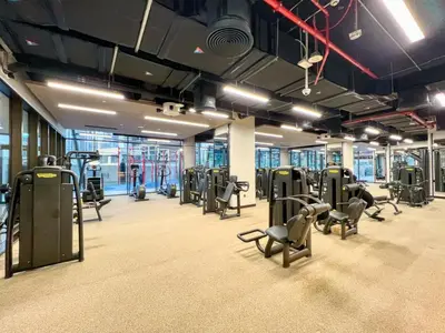 a gym with rows of treadmills and chairs at Brand New Business Bay 1 Bed with Burj Khalifa and Canal Views in Dubai