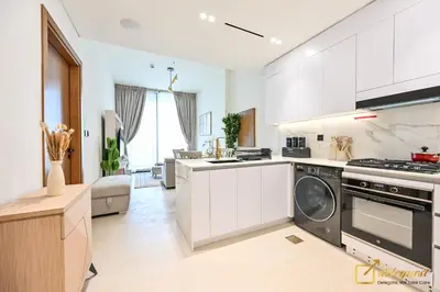 a white kitchen with a stove and a dishwasher at Marvelous 1BR in Binghati Amber by deleguest in Dubai