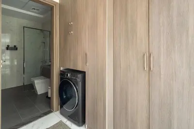a washer and dryer in a room with a bathroom at Frank Porter - Serenity Lakes 5 in Dubai