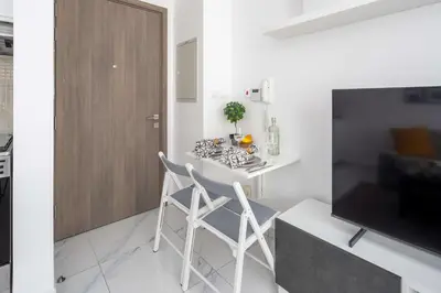 a living room with a table and chairs and a television at Frank Porter - Serenity Lakes 5 in Dubai