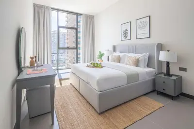 a bedroom with a bed and a desk and a window at Frank Porter - MBL Royal in Dubai
