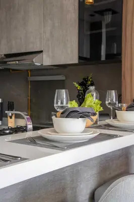 a table with plates and glasses on a kitchen counter at Frank Porter - MBL Royal in Dubai