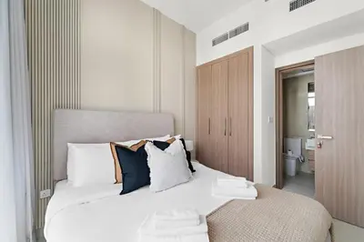 a bedroom with a large white bed with pillows at Silkhaus Stylish 2BDR in Azizi Gardens with Pool & Gym in Dubai