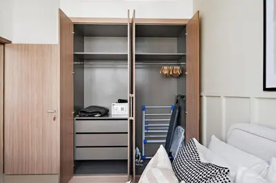 a bedroom with a bed and a closet with shelves at Silkhaus Stylish 2BDR in Azizi Gardens with Pool & Gym in Dubai