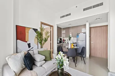 a living room with a couch and a kitchen at Silkhaus Stylish 2BDR in Azizi Gardens with Pool & Gym in Dubai