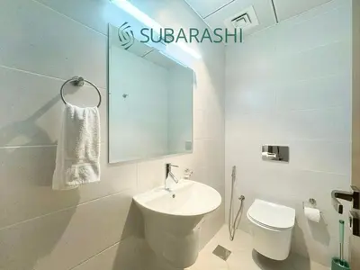 a bathroom with a sink and a toilet and a mirror at Stylish 1BR Apartment in JVC in Dubai