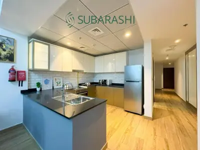 a kitchen with a sink and a refrigerator at Stylish 1BR Apartment in JVC in Dubai
