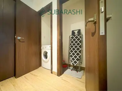 a laundry room with a washer and a washing machine at Stylish 1BR Apartment in JVC in Dubai