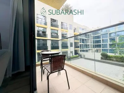 a balcony with a table and chairs in a building at Stylish 1BR Apartment in JVC in Dubai