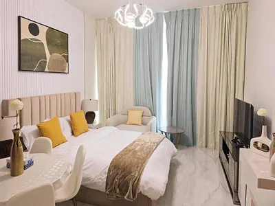a bedroom with a bed and a couch and a tv at Gemz by Danube - Al Furjan by Golden Casa in Dubai