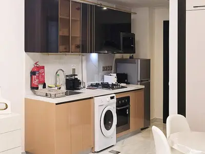 a kitchen with a washing machine and a washer at Gemz by Danube - Al Furjan by Golden Casa in Dubai