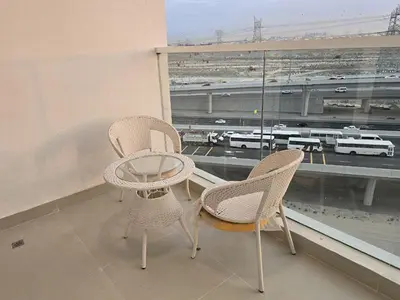 two chairs and a table in front of a window at Gemz by Danube - Al Furjan by Golden Casa in Dubai