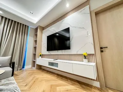a living room with a tv on a wall at Vserve High Floor Bliss in Dubai's Iconic Skyline in Dubai