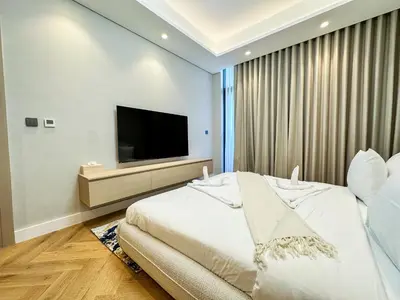 a bedroom with a large bed and a flat screen tv at Vserve High Floor Bliss in Dubai's Iconic Skyline in Dubai