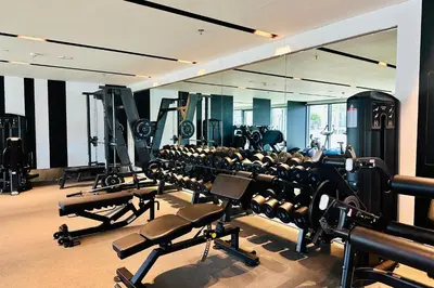 a gym with rows of tread machines and a mirror at Vserve I 1 BR - Luxury Escape in Business Bay in Dubai
