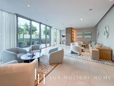 a living room with couches chairs and a table at LUX The Grande Signature Skyline Suite in Dubai