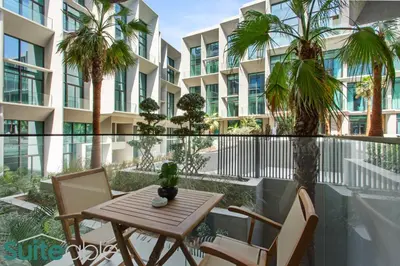 a table and chairs on a balcony with a building at Sophisticated Studio in The Autograph in Dubai