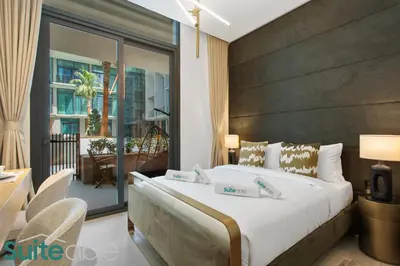 a bedroom with a large bed and a balcony at Chic Studio with Pool Access in The Autograph in Dubai