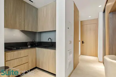 a kitchen with wooden cabinets and a sink at Chic Studio with Pool Access in The Autograph in Dubai