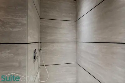 a bathroom with a shower with a wall at Chic Studio with Pool Access in The Autograph in Dubai
