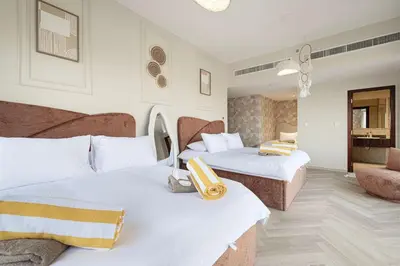 a hotel room with two beds and a living room at KYMA 2BDR JBR - Luxury Apartment with Full Panoramic Dubai Marina view in Dubai