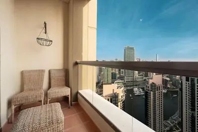 a balcony with two chairs and a view of a city at KYMA 2BDR JBR - Luxury Apartment with Full Panoramic Dubai Marina view in Dubai