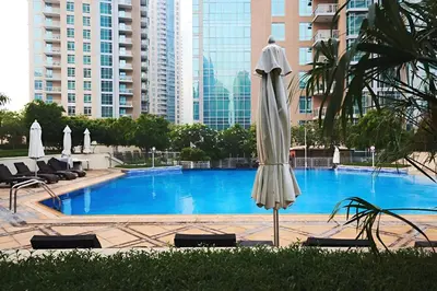 a white umbrella standing in front of a swimming pool at Best location in Downtown Dubai in Dubai