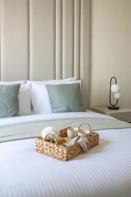 a basket on a bed with two candles and two cups at Frank Porter - Azizi Riviera 28 in Dubai