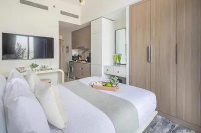 a bedroom with a white bed with a bowl of fruit on it at Frank Porter - Azizi Riviera 1 in Dubai