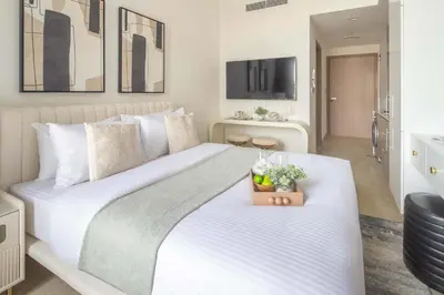 a bedroom with a large white bed with a plant on it at Frank Porter - Azizi Riviera 1 in Dubai