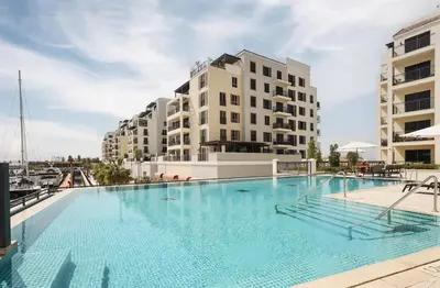 a large swimming pool in front of two buildings at Elite LUX Holiday Homes - 1BHK Beachside Retreat at Port De La Mer, Dubai in Dubai