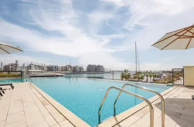 a swimming pool with a view of a city at Elite LUX Holiday Homes - 1BHK Beachside Retreat at Port De La Mer, Dubai in Dubai