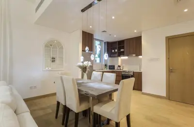 a kitchen and dining room with a table and chairs at Elite LUX Holiday Homes - 1BHK Beachside Retreat at Port De La Mer, Dubai in Dubai