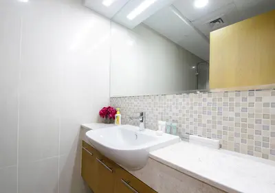 a bathroom with a sink and a mirror at Stylish 2BR in Bellevue Pool, Gym & Burj Views in Dubai