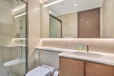 a bathroom with a sink and a toilet and a mirror at STAY BY LATINEM Luxury 1BR Holiday Home CVG 710 Near Burj Khalifa in Dubai