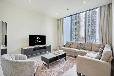 a living room with a couch and a tv at STAY BY LATINEM Luxury 1BR Holiday Home CVG 710 Near Burj Khalifa in Dubai