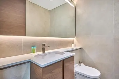 a bathroom with a sink and a toilet and a mirror at STAY BY LATINEM Luxury 1BR Holiday Home CVG 710 Near Burj Khalifa in Dubai