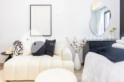 a living room with a white couch and a mirror at Bloomfields Modern Escape STU In JVC in Dubai